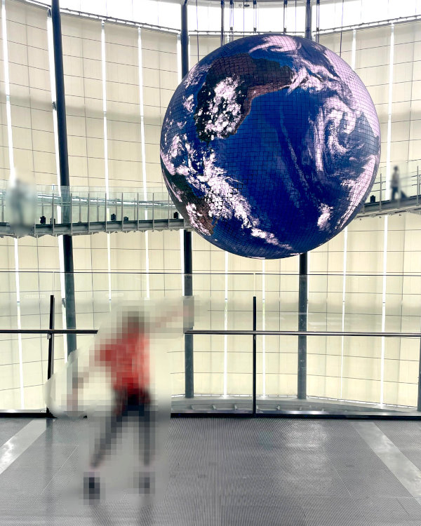 日本科学未来館の展示「ジオ・コスモス」でポーズをとる子供