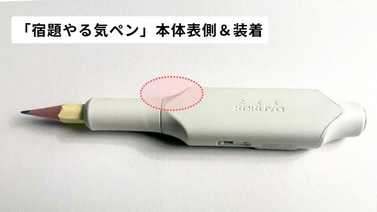 「しゅくだいやる気ペン」を鉛筆に装着した様子。鉛筆を持つ人差し指が当たる部分を赤点線で囲んで説明している写真。