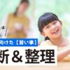 新年度に向けた習い事の決断と整理について。パソコンを前に笑顔を見せる女の子と、背景で見守る母親の様子